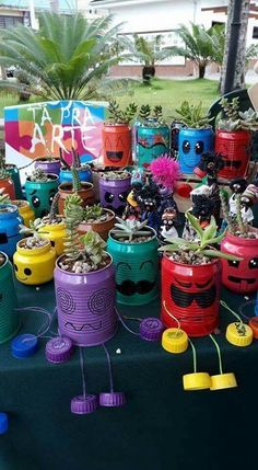 there are many colorful pots with plants in them on the table at this outdoor event