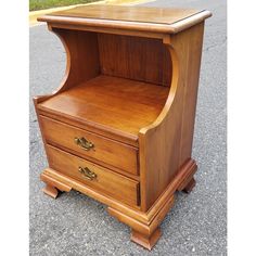 a wooden cabinet with two drawers on the bottom and one drawer open to show what's inside