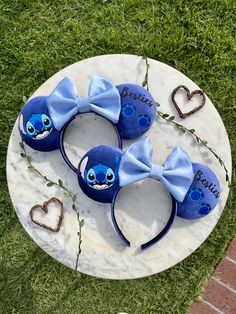 two mickey mouse ears with blue bows on a marble platter