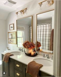 a bathroom with two sinks and candles on the counter