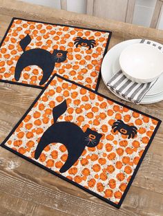 three placemats with cats on them sitting on a table next to a plate