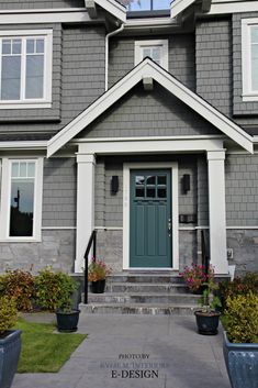 a gray house with white trim and blue door