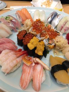 an assortment of sushi on a plate with chopsticks