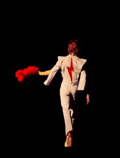 a man in white jumpsuit holding red fire extinguishers on black background