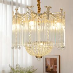 a chandelier hanging from the ceiling in a room with white walls and curtains