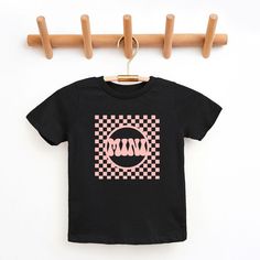 Looking for a cute tee for your kids? We have the perfect Checkered Mini graphic tee addition to their closet! Also available in toddler tees. Family Matching Black Shirt With Funny Print, Black Shirt With Graphic Print For Family Matching, Cute Black Short Sleeve T-shirt, Cute Black T-shirt With Graphic Design, Playful Black Cotton Shirt, Cute Black T-shirt With Screen Print, Cute Black T-shirt With Text Print, Cute Black Shirt For Streetwear, Black Cute Shirt For Streetwear