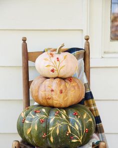 a stack of pumpkins sitting on top of a wooden chair