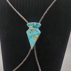 This turquoise bolo tie is a rare find!  The design is crafted from sterling silver and crowned with a carved turquoise stone in the shape of a large arrowhead. This piece bears the hallmark of the artist, which adds to its value.  The size of this piece makes it suitable for men and women alike.  If you're on the hunt for a piece of southwest history, this stunning bolo would make a wonderful gift for husband birthday, gift for dad, gift for best friend or self care gift for yourself, this beautiful bolo tie is just what you've been looking for! Southwestern Sterling Silver Bolo Tie As Gift, Handmade Sterling Silver Bolo Tie As Gift, Artisan Bolo Tie With Sliding Knot As Gift, Artisan Bolo Ties With Sliding Knot As Gift, Artisan Bolo Ties With Sliding Knot For Gift, Handmade Bolo Ties As Unique Gifts, Adjustable Sterling Silver Bolo Tie For Gifts, Blue Lariat Bolo Tie For Gift, Unique Silver Bolo Tie As A Gift