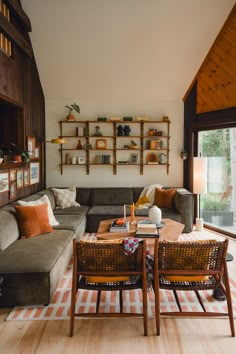 a living room filled with furniture next to a wooden floor covered in bookshelves