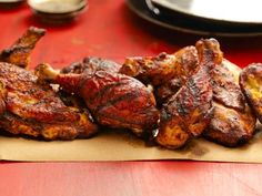 several pieces of meat sitting on top of a piece of paper next to a plate