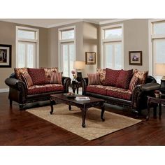 a living room with two couches and a coffee table in front of three windows