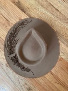 Western style rancher custom burned with delicately detailed feather. 100% wool hat by lack of colors. Size M western, boho, cowboy festival fashion  Only one like it Burned Straw Hat, Burned Fedora Hat Designs, Western Fedora With Feathers And Flat Brim, Western Style Fedora With Feathers And Flat Brim, Feathered Brimmed Felt Hat For Ranch, Feathered Flat Brim Felt Hat For Western-themed Events, Western Style Brimmed Fedora With Feathers, Southwestern Style Hat With Feathers And Flat Brim, Southwestern Hat With Feathers And Flat Brim