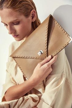 Symmetria mat clutch in sand beige.The perfect bag for all day needs, evening entertainment and going to a party.This adorable bag is handmade out of a supreme, cow, Italian leather in rsand beige color.It is hand stitched with waxed thread.The interior is fully lined with beige leatherette.The clutch closes with a metal twisted clasp and has metal endings, available in silver and gold color. The pictures show the clutch with gold metal hardware.Dimensions:Height 18 cm (7")Length 30 cm (11,8")Al Modern Beige Clutch For Evening, Luxury Brown Envelope Clutch, Modern Beige Clutch For Daily Use, Beige Leather Clutch For Office, Luxury Beige Envelope Clutch, Beige Leather Envelope Bag, Chic Everyday Envelope Clutch, Beige Envelope Clutch For Evening, Chic Beige Clutch For Office