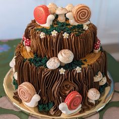 there is a chocolate cake decorated with candies and snails on it's side