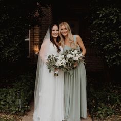 two women standing next to each other holding bouquets