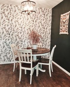 a dining room table with four chairs and a potted plant on top of it