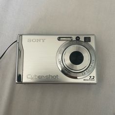 a silver camera sitting on top of a bed