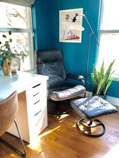 an office with a chair, desk and plant in the corner on the hard wood floor