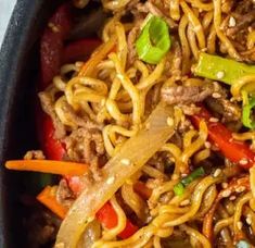 a bowl filled with noodles, meat and vegetables