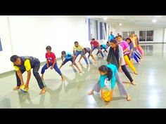 a group of people standing around each other in a room with yellow and blue balloons