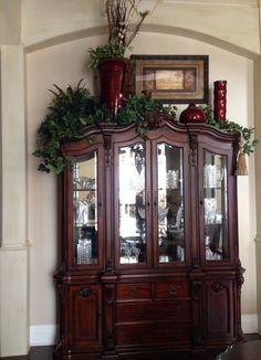 a wooden china cabinet with plants on top