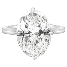 an oval cut diamond engagement ring on a white background