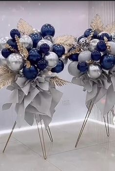 two silver and blue christmas decorations on sticks