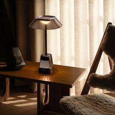 a teddy bear sitting on a chair next to a table with a lamp on it