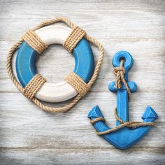 an anchor and life preserver on a wooden background