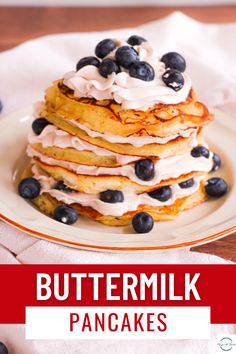 a stack of pancakes topped with blueberries and whipped cream