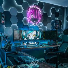 a computer desk topped with a monitor and keyboard in front of a neon wallpaper