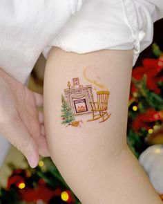 a woman's arm with a tattoo on it and a rocking chair in front of a christmas tree