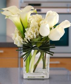 a vase filled with white flowers on top of a counter