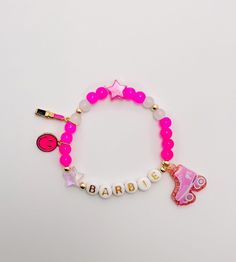 Festive, fun, lightweight Barbie bracelet for kids. Made with a mixture of pink, clear, and gold filled beads in a mixture of sizes 4 mm and 6 mm, star beads, and a smiley face charm,lipstick charm, and barbie charm on stretch cord. These festive, trendy, fun bracelets are customized just for you and those special people in your life! Each one is perfect on its own or layered with even more bracelets! Message me for layering and stack ideas! These are perfect gifts for birthdays or holidays, gif Pink Charm Bracelet With Round Beads For Friendship, Pink Round Beads Charm Bracelet For Friendship, Personalized Pink Name Bracelet For Party Favors, Pink Novelty Jewelry For Birthday, Personalized Pink Charm Bracelet For Birthday, Pink Bracelet Wristband For Birthday, Pink Wristband For Birthday, Pink Adjustable Themed Charm Bracelet, Pink Themed Adjustable Charm Bracelet