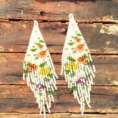 These woven bead earrings  with a beautiful fringe made with white and several other colors of MIYUKI Delica Japanese beads that form a delicate and colorful pattern of flowers throughout the rhombus, using a strong thread to join them together. Add a little elegance and sophistication to your outfit with these beaded earrings. The delicate floral patterns make these stand out, while the texture and colors make them perfect to wear on any occasion. Miyuki Delica's white beads contrast beautifully with the other colors, giving them an amazing look that will complement any outfit. They are very light and easy to carry and are perfect for day to day Please choose the ear hook of your preference, we offer 8 ear hook options to meet your metal sensitivity needs: 1) Nickel free/ Stainless Steel White Handwoven Earrings For Summer, White Beaded Fringe Earrings For Festival, White Beaded Fringe Festival Jewelry, Festival White Beaded Fringe Jewelry, Bohemian White Chandelier Earrings For Festivals, White Dangle Tassel Earrings For Festivals, Bohemian White Beaded Fringe Earrings, White Handwoven Drop Earrings, Handmade White Bohemian Tassel Earrings