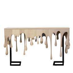 a table with dripping white paint on it's sides and black metal legs, against a white background