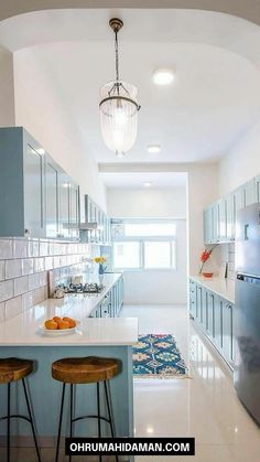 a kitchen with two stools next to an island