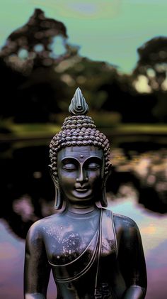 a buddha statue sitting in front of a body of water