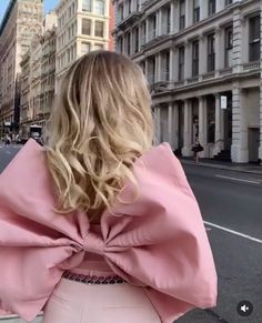 a woman with blonde hair is standing on the street