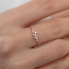 a woman's hand with a diamond ring on top of her finger and the other hand holding it