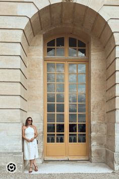 a woman is standing in front of a door