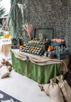 a table filled with lots of treats on top of a green cloth covered tablecloth