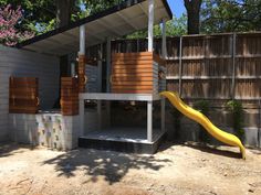 a small house with a slide in the yard