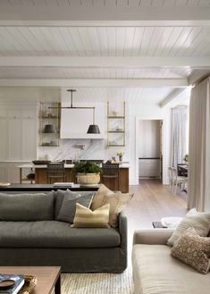 a living room filled with furniture next to a kitchen