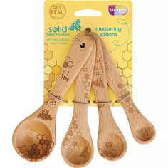 three wooden spoons with bees on them in front of a package for selling them