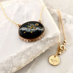 A beautiful, handmade reminder of our place in the universe and connection to each other. This Solar System Necklace has golden glass microbeads carefully hand placed to create our sun and planets on a backdrop of the shimmering milky way galaxy made of mica. The scene floats in a sparkling inky resin and is covered with a clear dome, adding dimensions and depth to this celestial scene. Stamped with the word STARDUST, the bezel is hand cast from your choice of sterling silver or bronze and hangs Necklace Planet, Virgo Jewelry, Sun And Planets, Solar System Necklace, Virgo Necklace, Galaxy Necklace, Planet Necklace, Astrology Necklace, Zodiac Sign Necklace