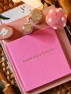 a pink book with the words tooth fairy letters written on it next to other items