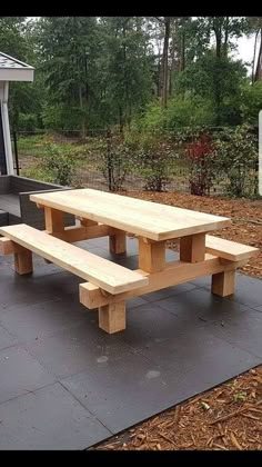 a wooden picnic table sitting on top of a cement slab