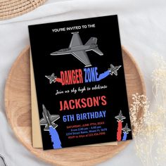 an airplane birthday party card on a wooden plate