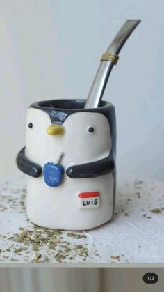 a ceramic penguin toothbrush holder on a table